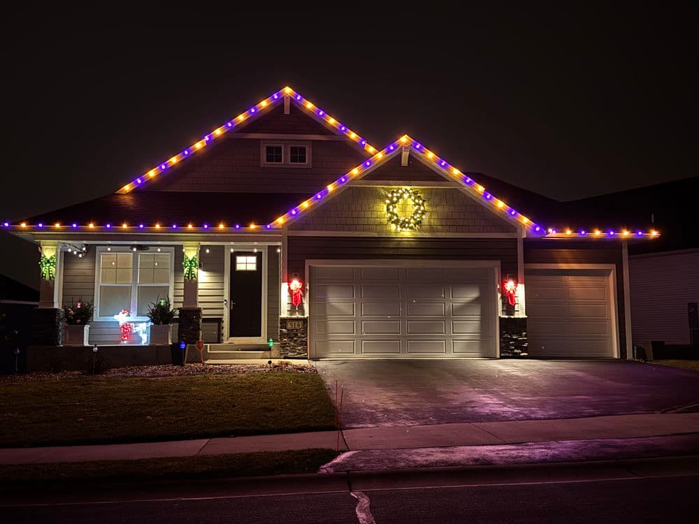 Festively lit house with colorful lights and holiday decorations at night.